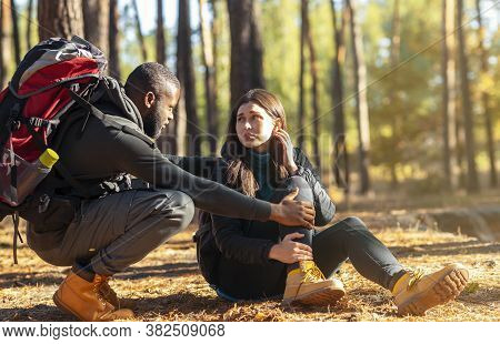 African Guy Comforting His Caucasian Pretty Girlfriend Hurt Her Ancle While Camping In Forest, Free 