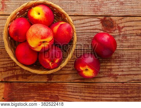 Nectarine. Ripe Juicy Organic Nectarines (peaches) In A Wicker Basket. Whole Fruit On A Wooden Table