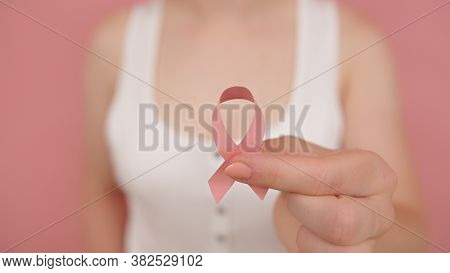 Pnk October, Brest Cancer Awareness Ribbon In The Hand Of A Young Unrecognzable Woman. High Quality 