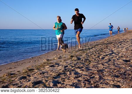 Ukraine, Karolino-bugaz - August 18, 2020: Boys Teenagers Athletes Run Along The Seashore. Sports On
