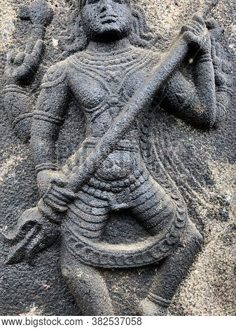 Sculpture Of Shiva Holding A Trishula. Bas Relief Sculpture Carved In The Stone Wall Of Shiva Temple