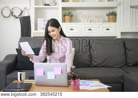 A Business Woman Is Working With Laptop Computer And Analyzing Business Growth Graph Data In Living