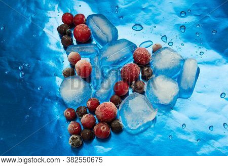 Frozen Berries With Ice In The Shape Of A Heart On A Blue Background.