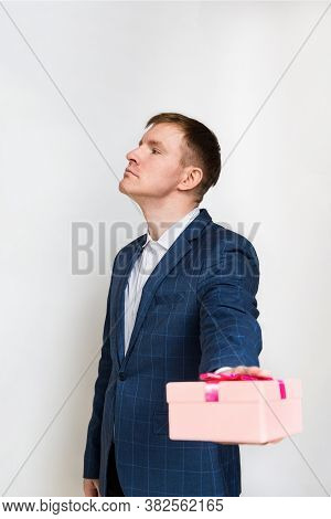 Young Man With Short Dark Hair And No Beard Reaches Out And Returns The Gift Box With An Aggrieved E