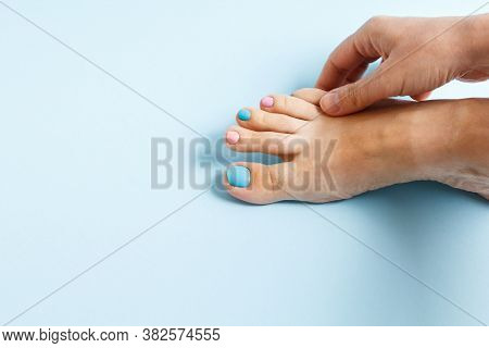 Female Feet At Spa Salon On Pedicure Procedure. Female Leg With Nails Painted With Multi-colored Nai