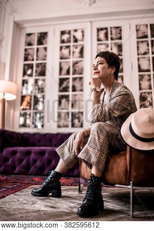 Dreamy Smiling Short-haired Brunette Woman In Elegant Business Plaid Pantsuit With Rolled Up Sleeves