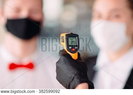 The Manager Of A Restaurant Or Hotel Checks The Body Temperature Of The Staff With A Thermal Imaging