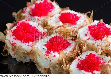 Sushi Rolls With Tuna Or Salmon Shavings On A Black Background.