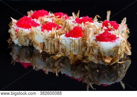 Sushi Rolls With Tuna Or Salmon Shavings On A Black Background.