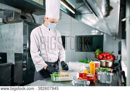 Food Delivery In The Restaurant. The Chef Prepares Food In The Restaurant And Packs It In Disposable