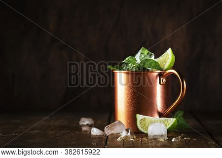 Moscow Mule Or Mint Julep Cocktail In Copper Mug With Lime, Ginger Beer, Vodka And Mint. Wooden Tabl