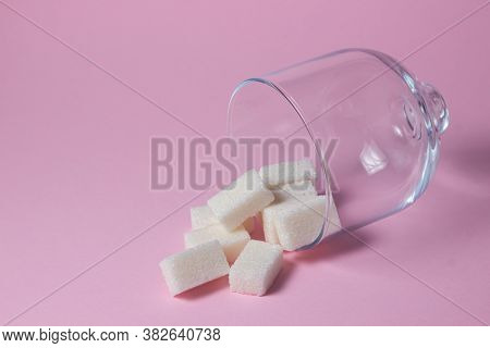 Sugar Cubes On A Pink Background. Sugarcubes Spilled Out Of Glassware