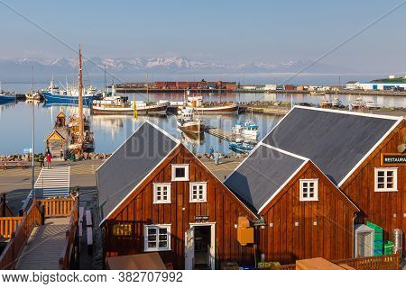 Husavik, Iceland- 25 August 2015: View Of The Husavik Harbor. Fishing Boats In The Bay, Wooden Build