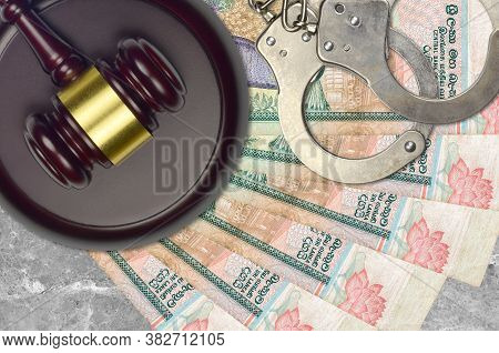 1000 Sri Lankan Rupees Bills And Judge Hammer With Police Handcuffs On Court Desk. Concept Of Judici