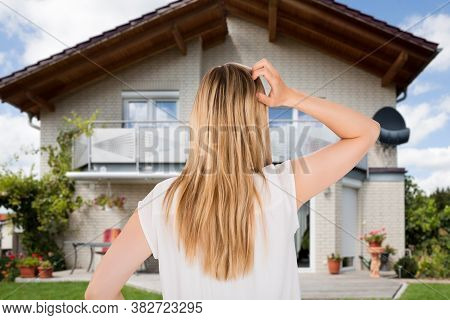 Confused Home Buyer Scratching Head In Front Of Real Estate