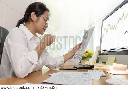 Business Woman Working In Office With Computer Holding Chart Report Paper And Looking. Business Peop