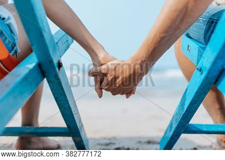 Couple Sitting On The Deck Chairs At The Beach. Honymoon, Love, Travel Or Vacation Concept.