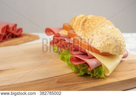 Mortadella Sandwich, Lettuce, Tomato And Cheese On A Polished Board And Slices Of Mortadella And Che