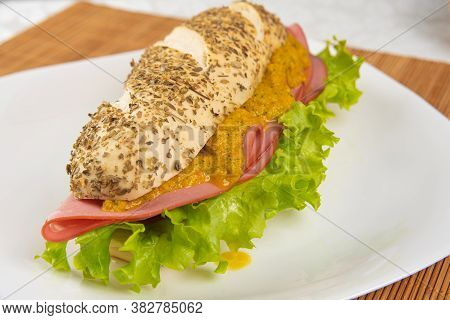 Mortadella And Lettuce Sandwich With Oregano-covered Bread, On A White Plate And A Bamboo Mat And Pe