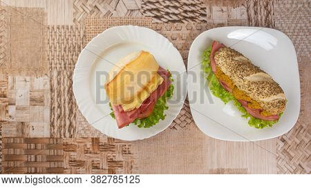 Mortadella, Lettuce And Cheese Sandwiches And Pepper And Mustard Sauce On White Plates On A Table Wi