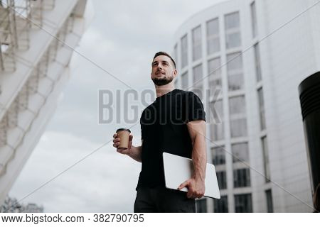 Young Handsome Man Walking Down The Street, Carrying His Laptop While Drinking Coffee On The Go, Lun