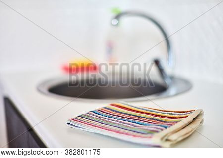 Kitchen Towel And Sink Without Dirty Dishes Background. Dishcloth On Kitchen Countertop. Cleaning An