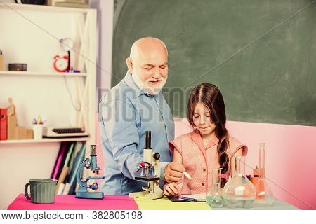 Little Girl With Man Tutor Study Science. Pedagogue Career. Experienced Pedagogue. School Lesson. Go