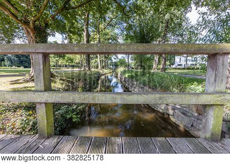 Keutelbeek Stream With Lush Green Trees On The Shore And The Reflection Of Sunlight In The Water See