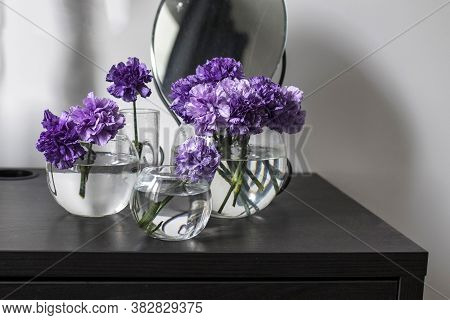 Bridal Bouquet Of Lilac Carnations In A Round Glass Vase