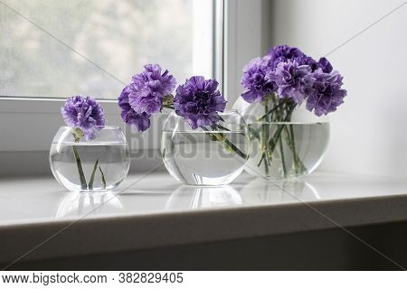 Bridal Bouquet Of Lilac Carnations In A Round Glass Vase