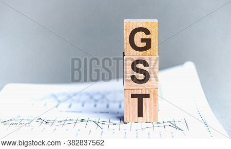 Gst Word Written On Wood Block. Wooden Block With Words Gst - Acronim Gst - Goods And Services Tax.