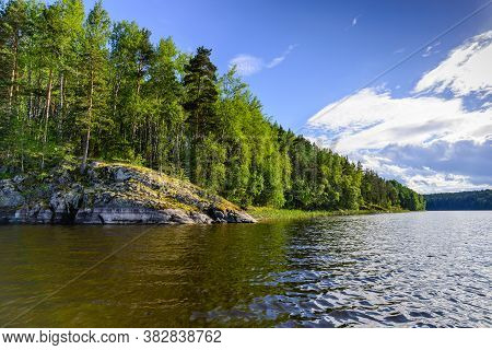 Beautiful Rocky Coast Of The Lake Ladoga Overgrew The Forest. Sunny Day, Karelia, Russia.