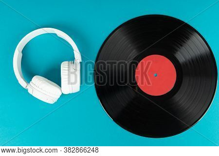 White Wireless Headphones And Old Vinyl Record. Music Concept. Rretro Sound System