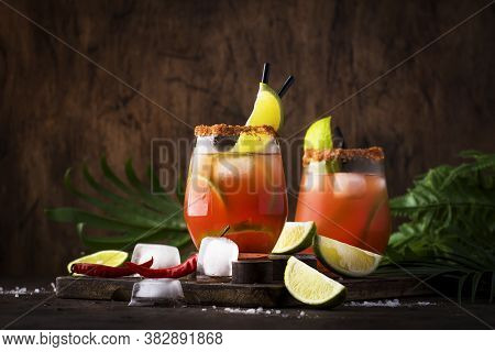 Michelada - Mexican Alcoholic Cocktail With Beer, Lime Juice, Tomato Juice, Spicy Sauce And Spices, 