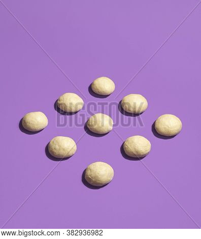 Raw Bread Buns Dough Displayed Symmetrically On A Seamless Purple Background. Unbaked Dough Balls. L