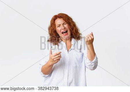 Technology And Communcation Concept. Portrait Of Winning Happy Middle-aged Redhead Woman Rejoicing O
