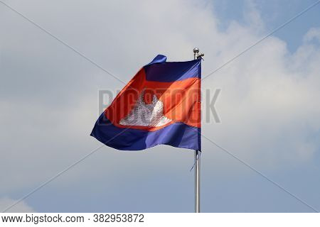 National Flag Of Cambodia On Bright Blue Sky Background. Blown Away By Wind. Cambodia Is One Of The 