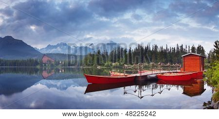 Paisaje de montaña con barcos de color rojo en el lago. Lago Strbske Pleso en los Altos Tatras, Eslovaquia, Europ