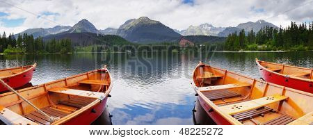 Mountain panorama with red boats on the lake. Lake Strbske Pleso, High Tatras, Slovakia, Europe