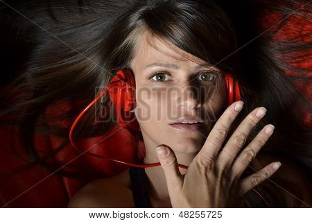 Красивая молодая женщина с красной Наушники