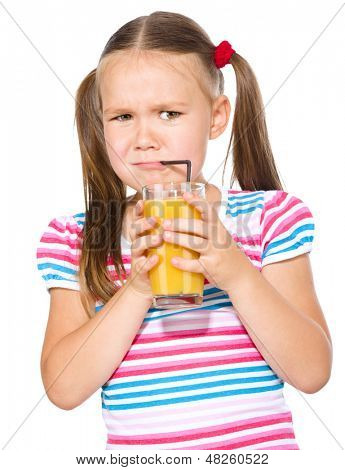 Liten flicka motvilligt dricka apelsinjuice med halm, isolerade över vita