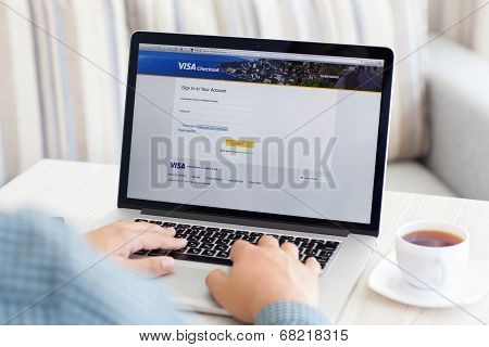 Man Sitting At The Macbook Retina With Site Visa On The Screen