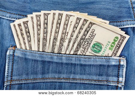 A Hundred Dollar Bills Sticking In The Back Pocket Of Denim Blue Jeans