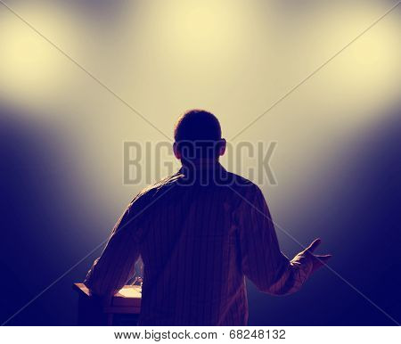 a young man in front of a podium and an audience