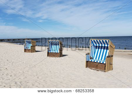 Empty sunbathing baskets on the beach.