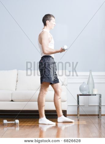 Uomo utilizzando pesi del braccio In salotto