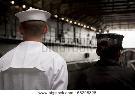 NEW YORK - MAY 22: Two sailors stand at the top of the ramp of the well deck aboard the amphibious dock landing ship USS Oak Hill (LSD 51) moored at Pier 92 for Fleet Week NY on May 22, 2014.
