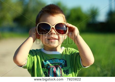 Menino de óculos de sol e verão ensolarado
