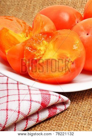 Ripe Persimmon Fruits On White Plate And Napking, Sacking Background