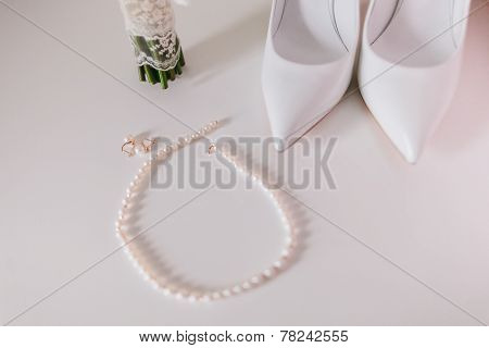 Wedding Pearl Earrings And Necklace Close Up With Wedding Shoes And Bouquet Background